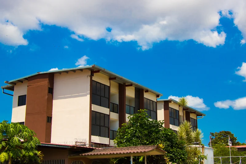 The building among the houses and trees of Ciudad Radial